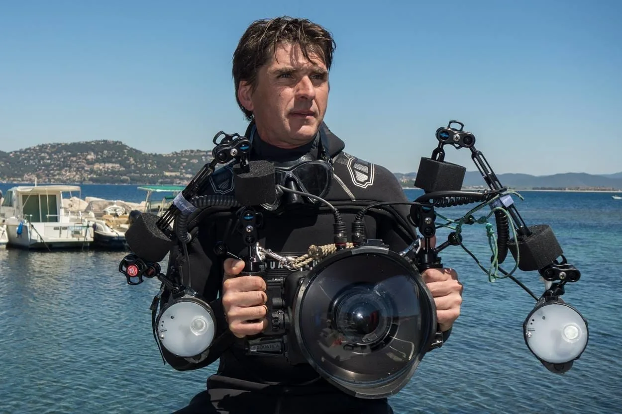 Fabrice Guerin, photographe, en sortie sur un bateau avec son appareil photo à la main.