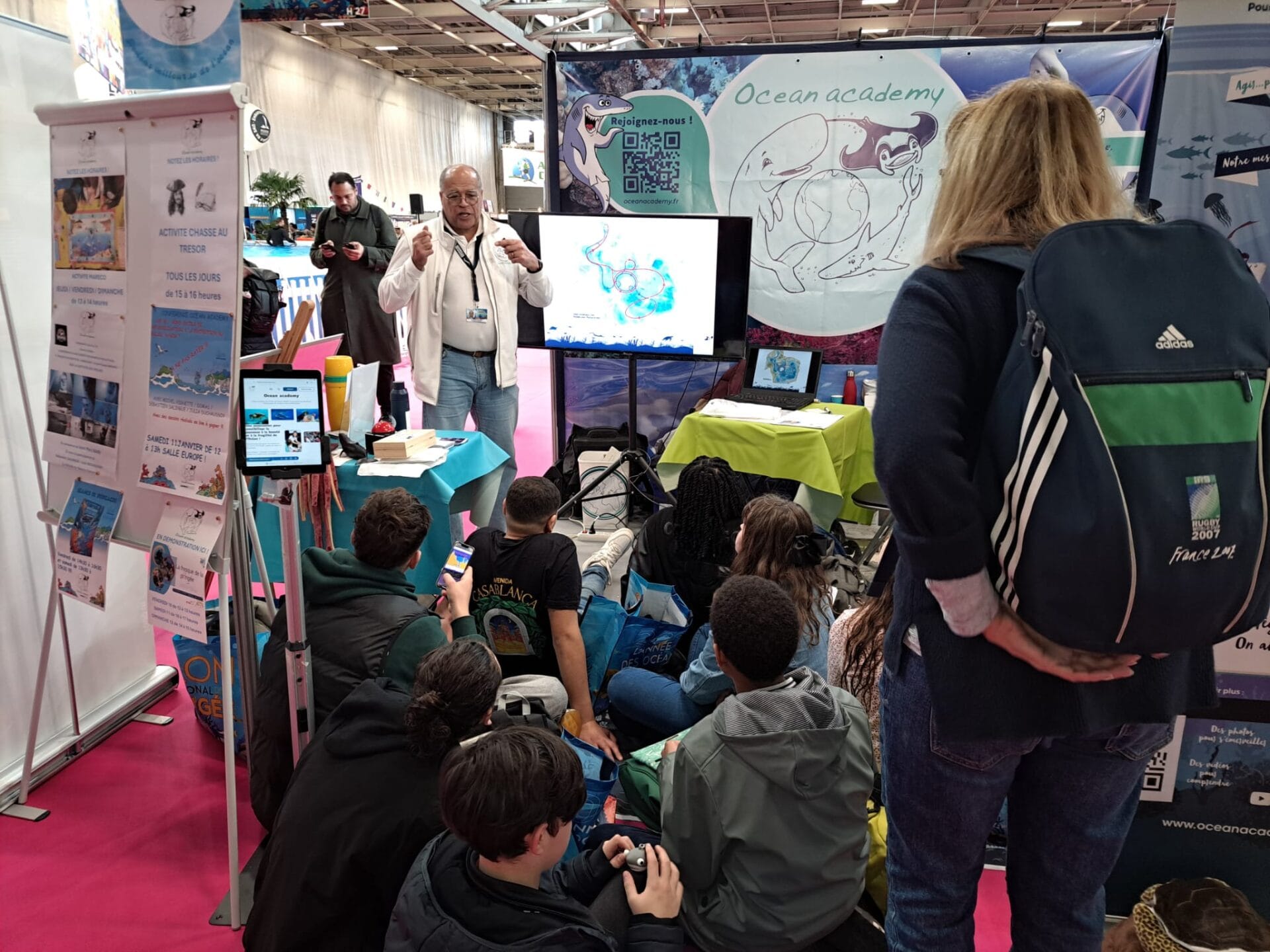 Patrick, animateur pour Ocean academy, en pleine discussion avec un groupe de jeunes sur le stand